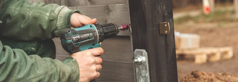 Person verschraubt Holzbalken mit Akkuschrauber